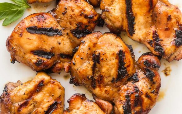 square image of grilled boneless chicken thighs on white plate