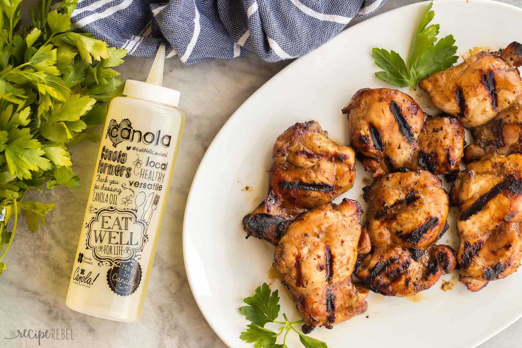 grilled chicken thighs on plate with canola oil bottle