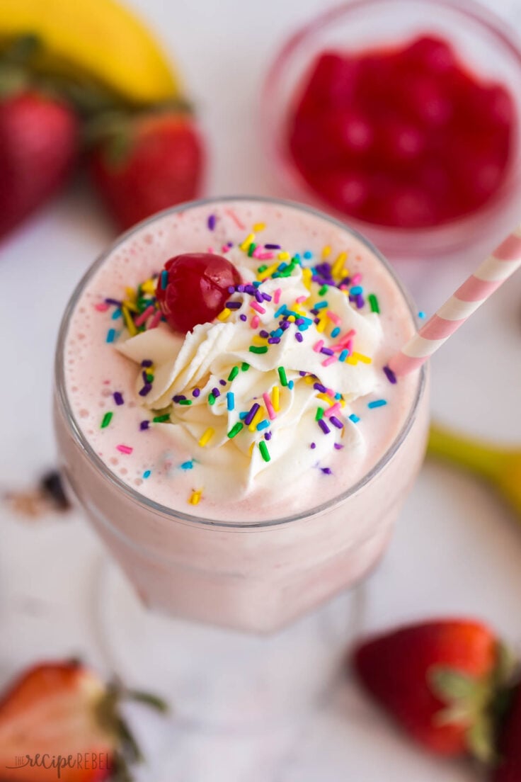 overhead image of strawberry milkshake with whipped cream and sprinkles