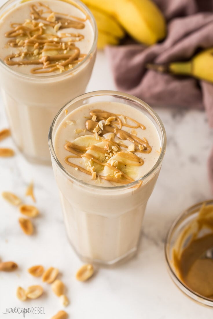 close up image of peanut butter banana smoothie with sliced bananas and peanut butter drizzle