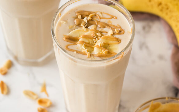 close up image of peanut butter banana smoothie in glass