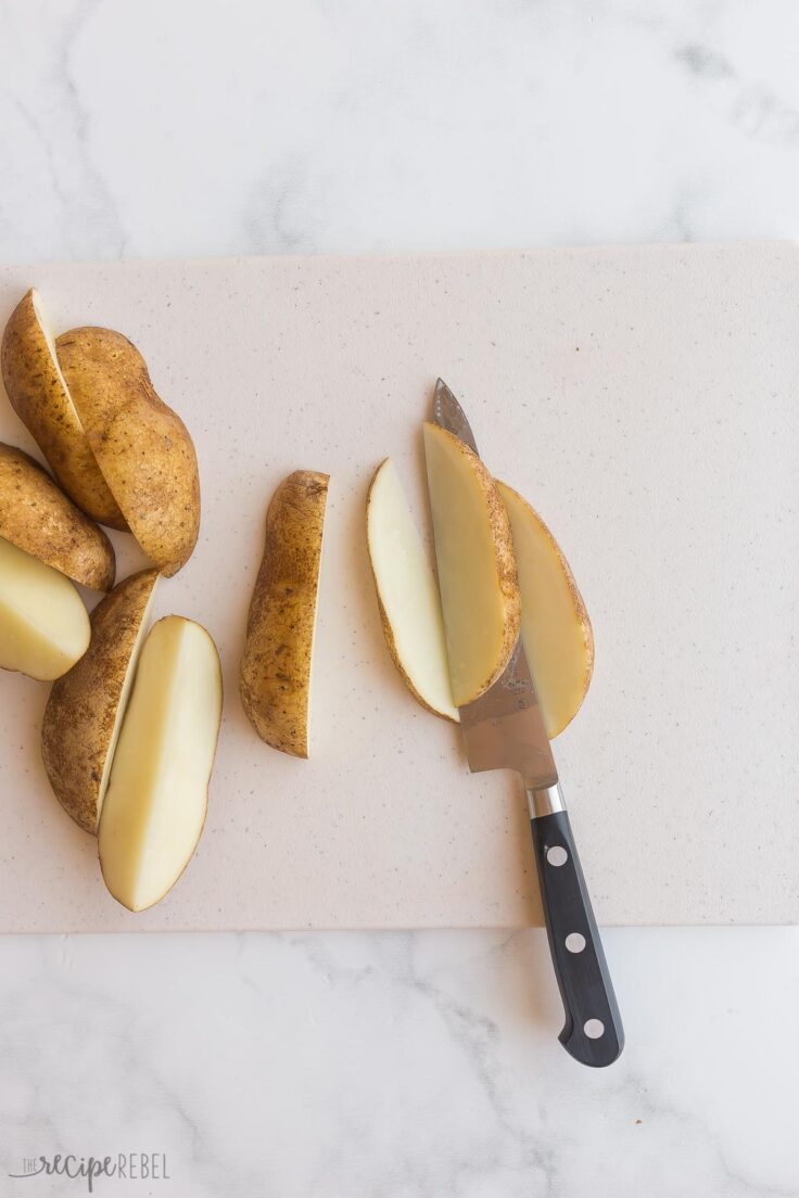 slicing quartered potatoes into wedges
