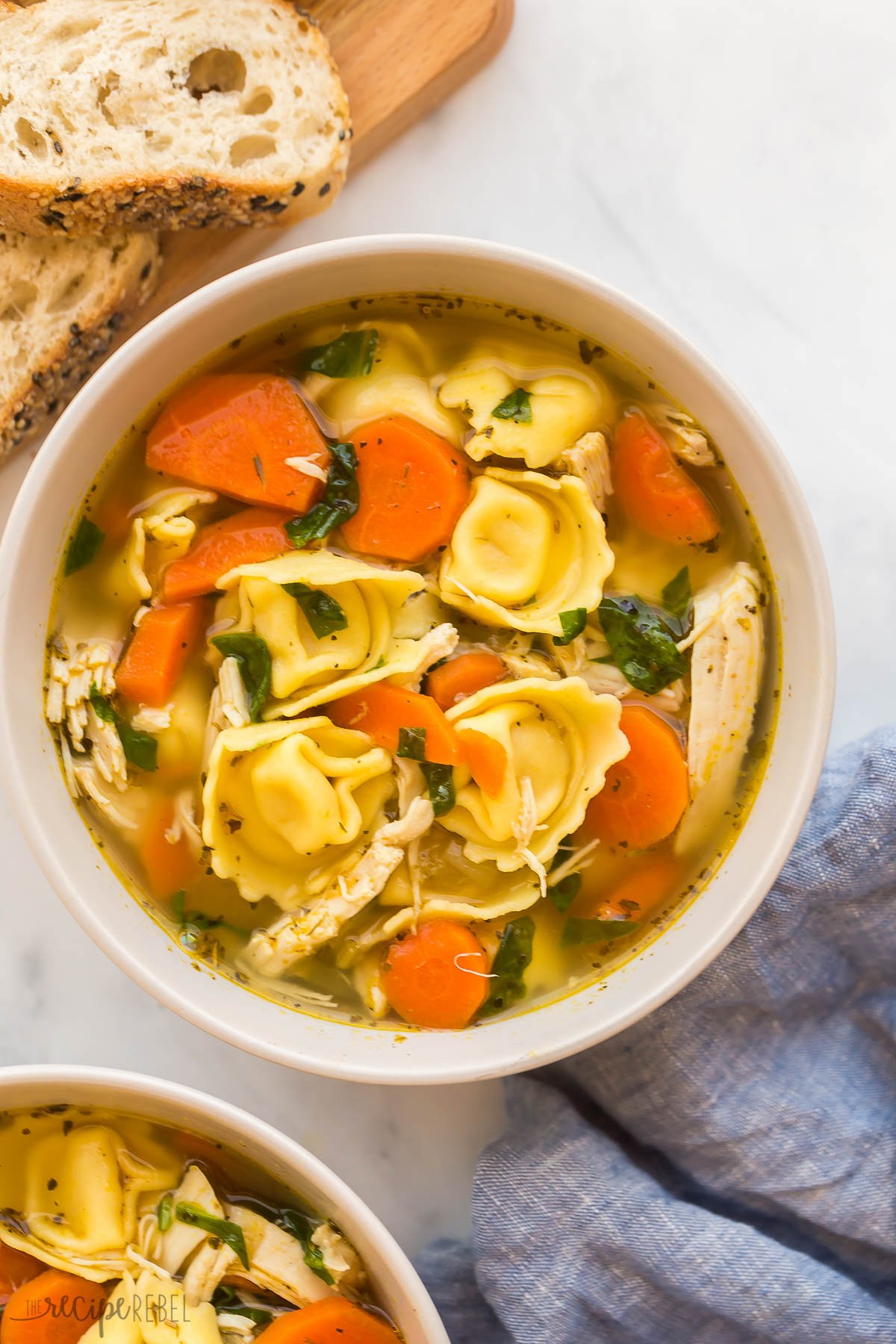 close up overhead image of a bowl of chicken tortellini soup