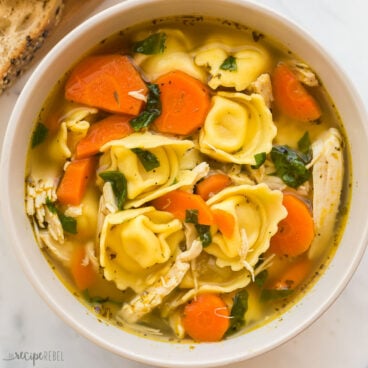 square overhead image of a bowl of chicken tortellini soup