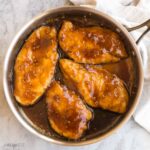 square image of honey garlic chicken breasts in steel pan
