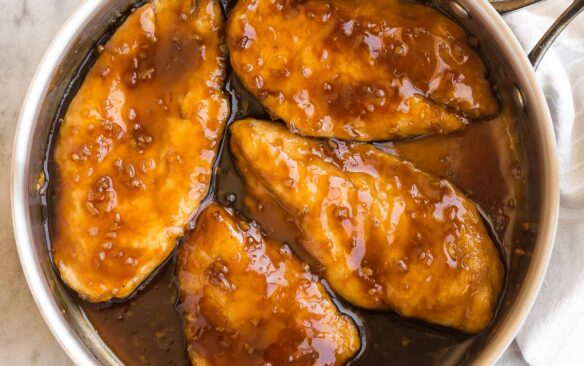 square image of honey garlic chicken breasts in steel pan