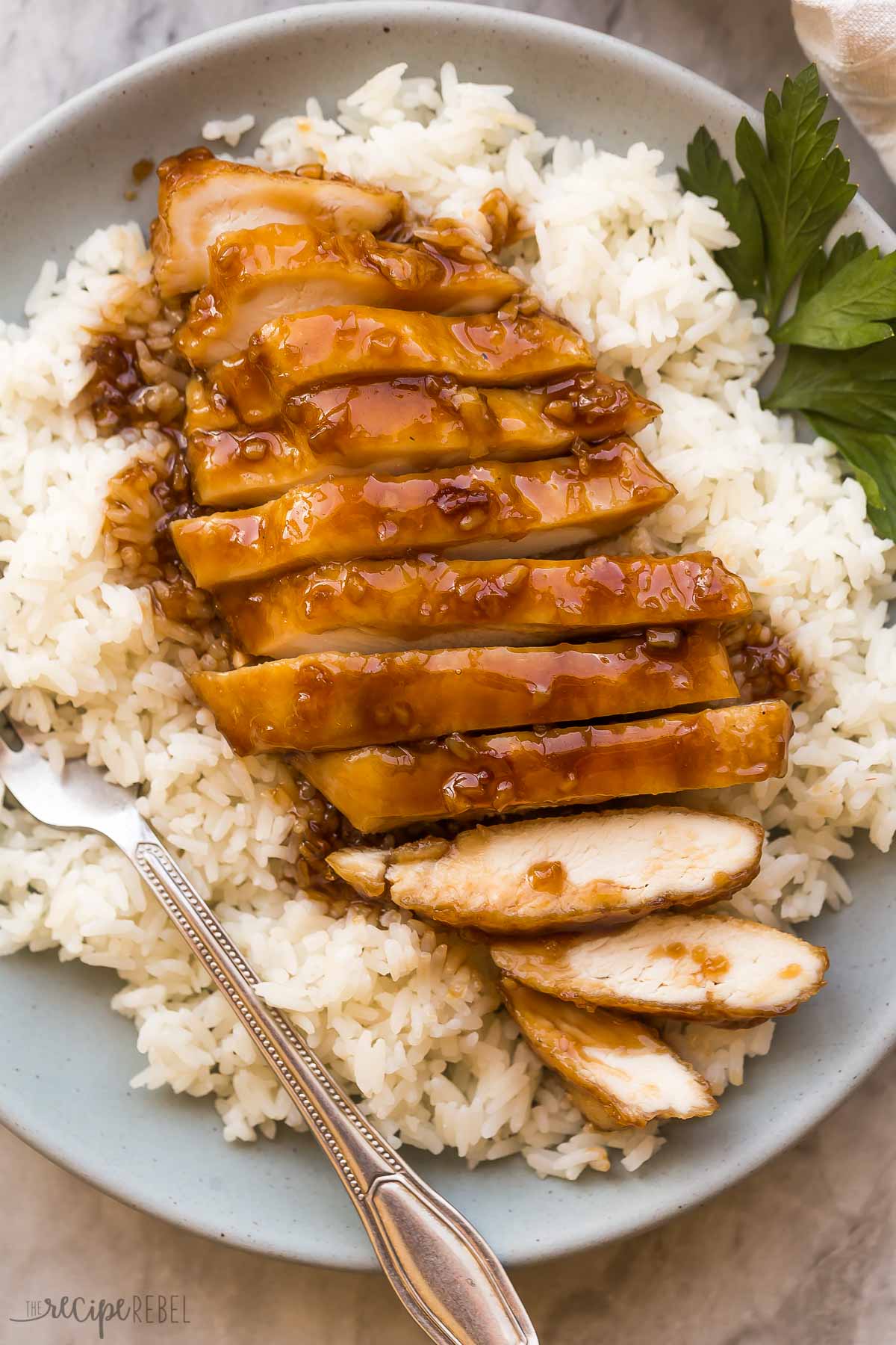 sliced honey garlic chicken breast on a bed of rice