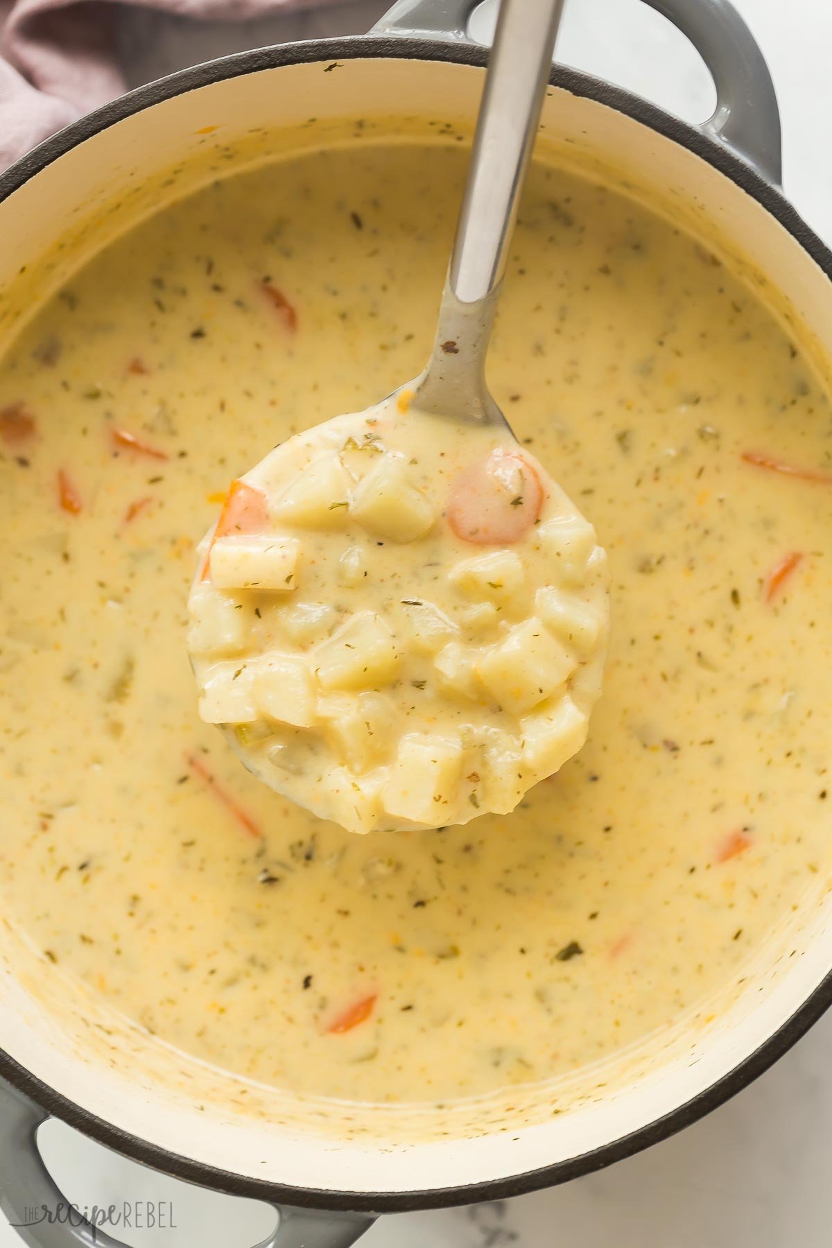 ladle scooping potato soup from pot