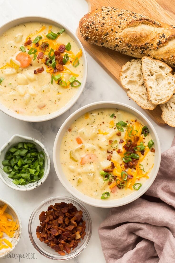 overhead image of two bowls of potato soup with toppings on the side