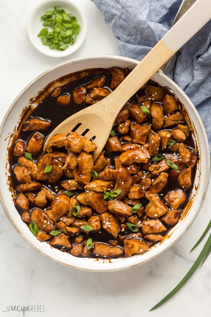 overhead image of teriyaki chicken in skillet with wooden spoon