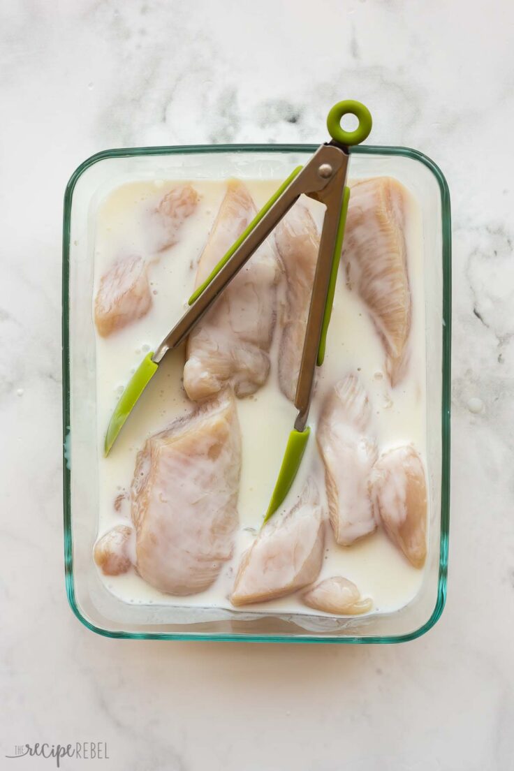 pieces of chicken breast soaking in buttermilk