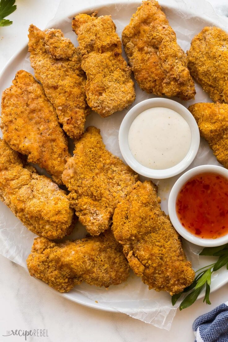 overhead image of a platter of air fryer fried chicken breasts with two sauces
