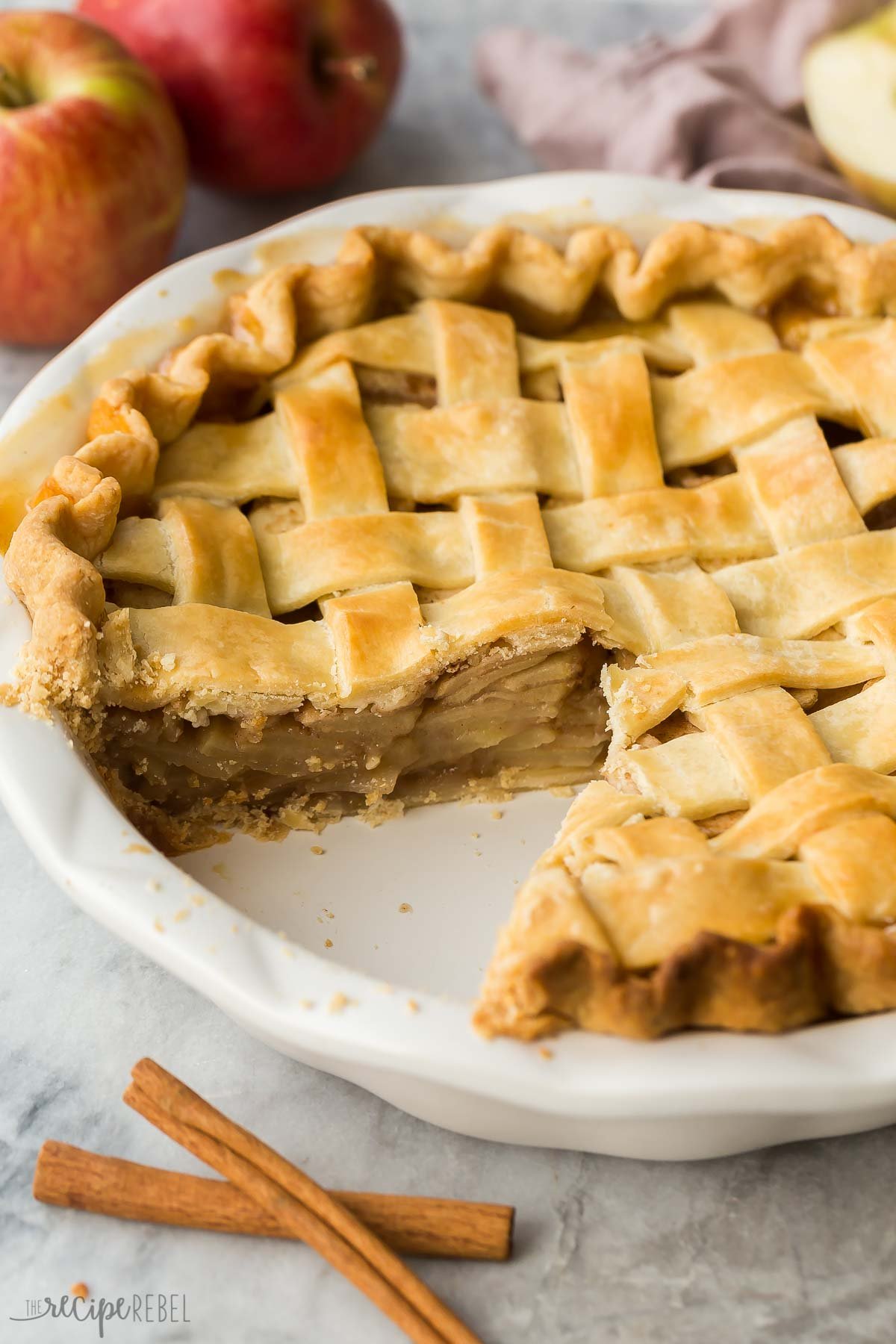 whole apple pie in plate with piece missing