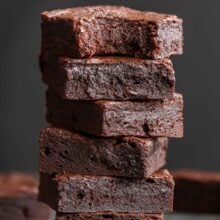tall stack of brownies on black background.