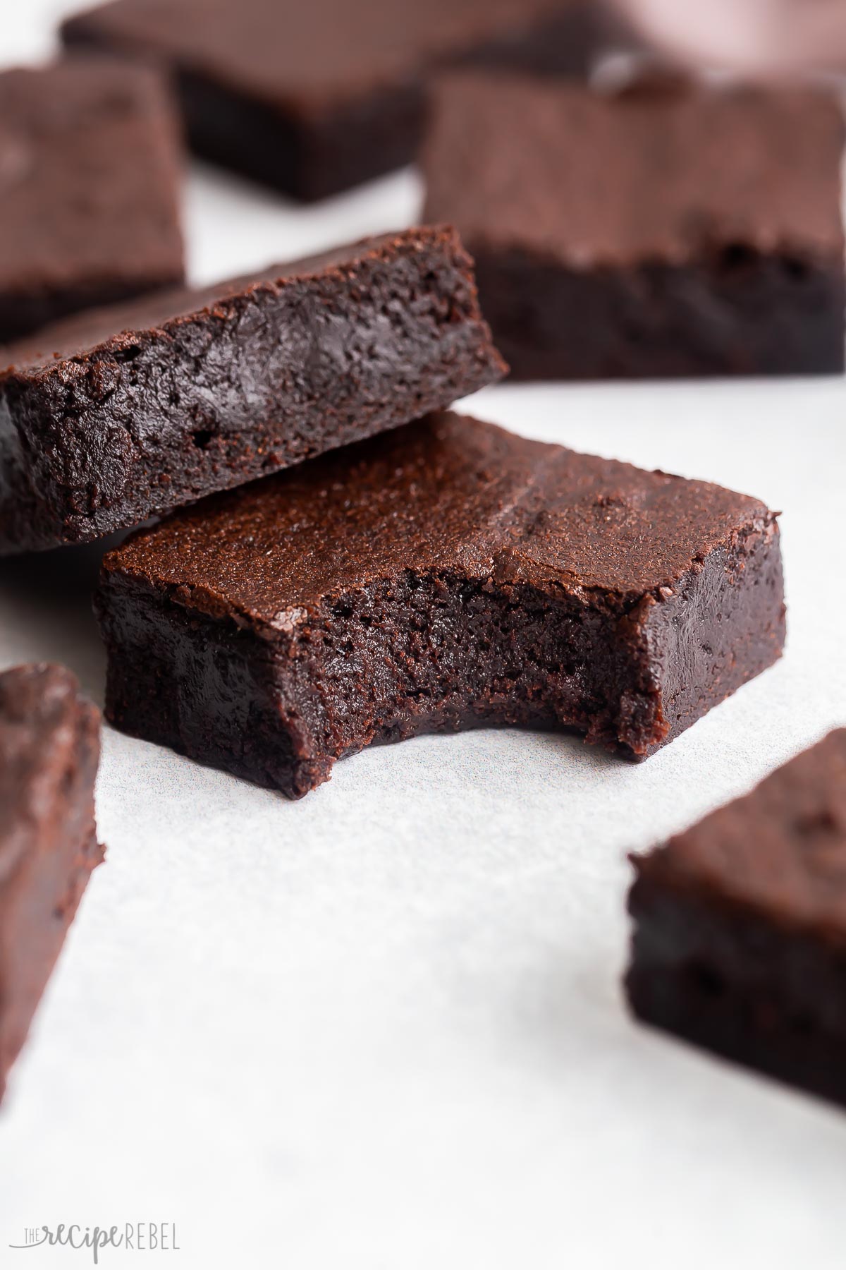 two brownies stacked with a bite out of one.