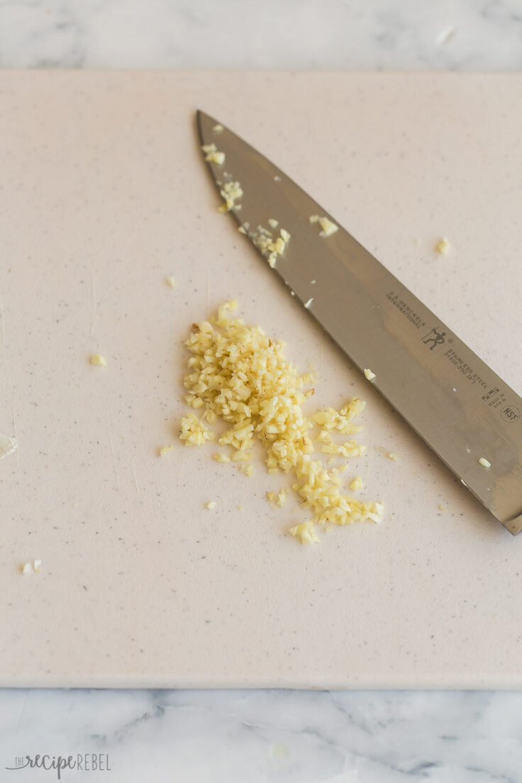 freshly chopped garlic on a white cutting board