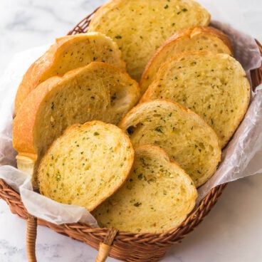side angle photo of basket with garlic bread slices