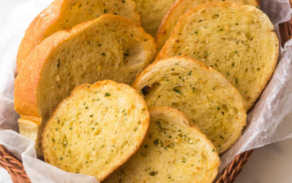 side angle photo of basket with garlic bread slices