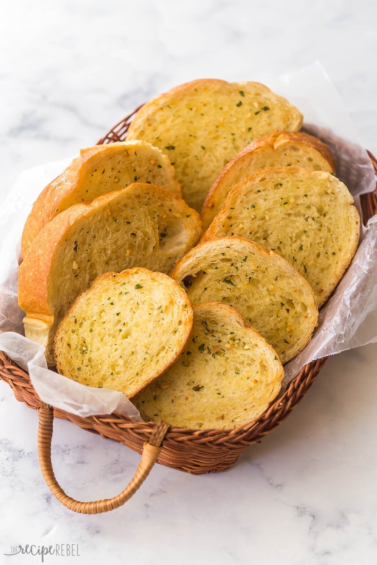 side angle photo of basket with garlic bread slices