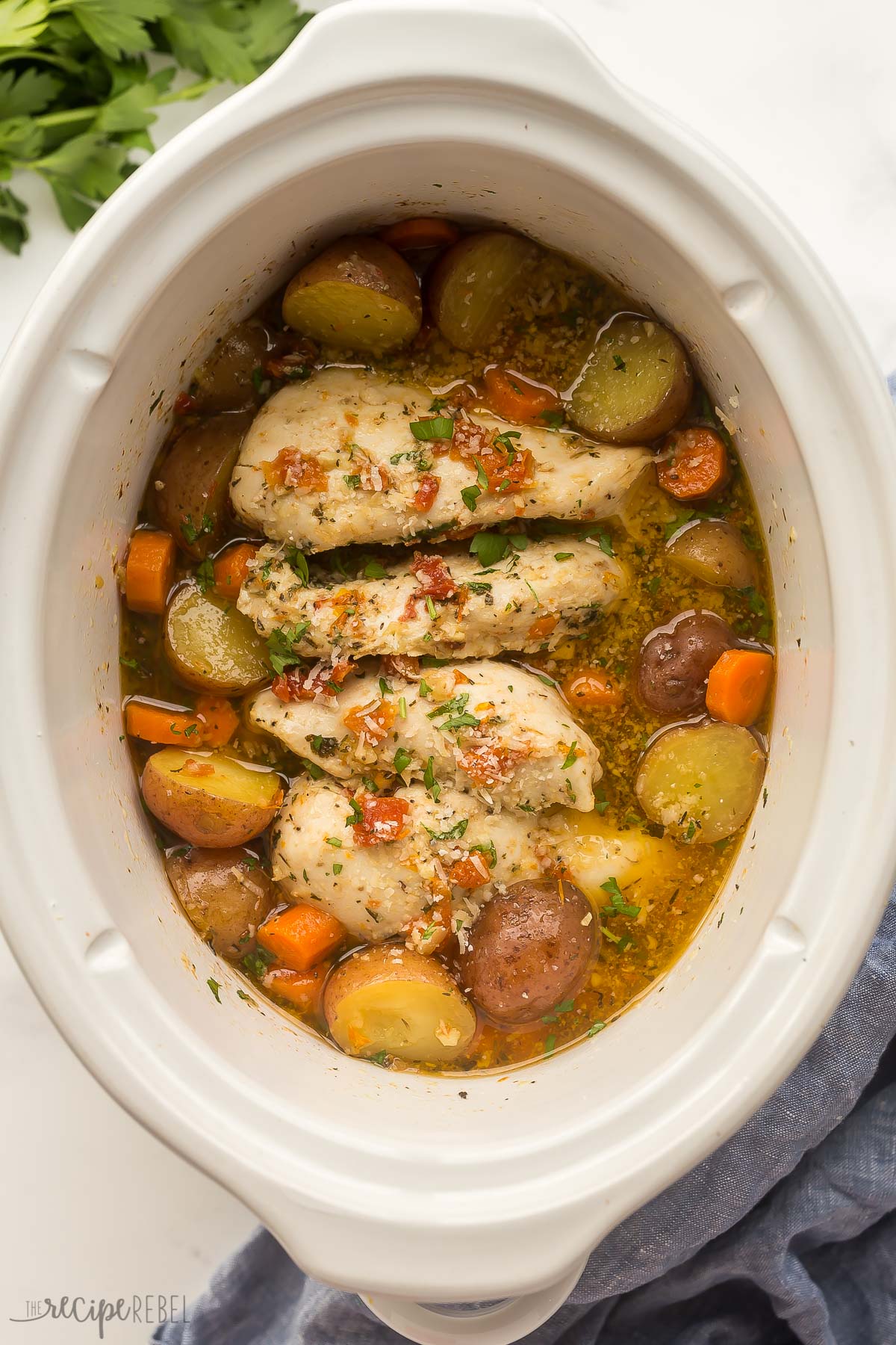 This Crockpot Chicken and Potatoes is slow cooked in a broth flavored with sun dried tomatoes and Italian herbs. It's an easy crockpot meal that requires only 10 minutes prep! #slowcooker #crockpot #chicken | chicken breast ideas | easy crockpot meals | crockpot recipes | slow cooker meals | easy dinner ideas chicken potatoes and carrots in slow cooker with sun dried tomato sauce