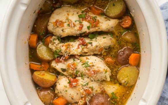square image of crockpot chicken and potatoes with sun dried tomato sauce