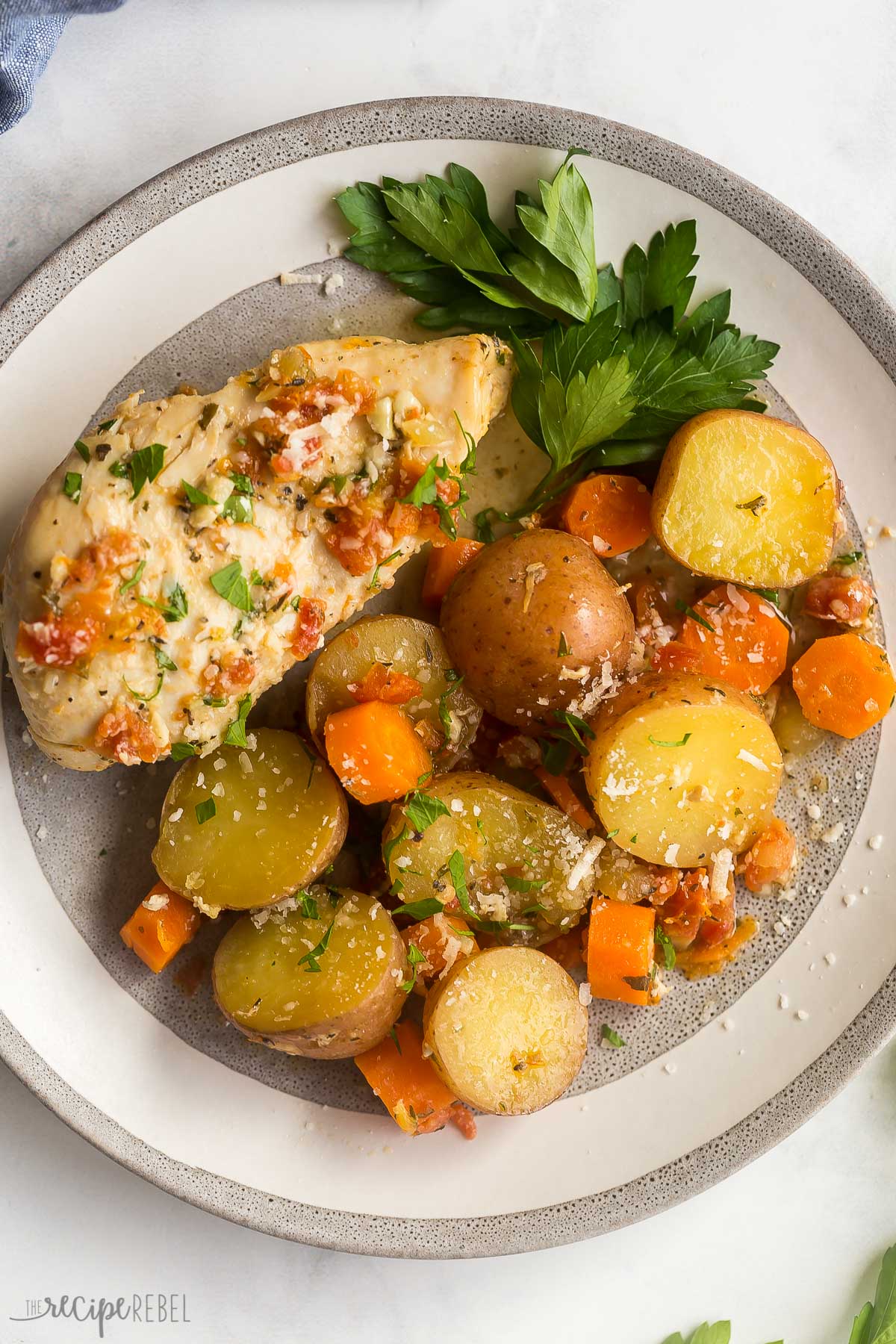 overhead image of crockpot chicken breast on plate with potatoes and carrots