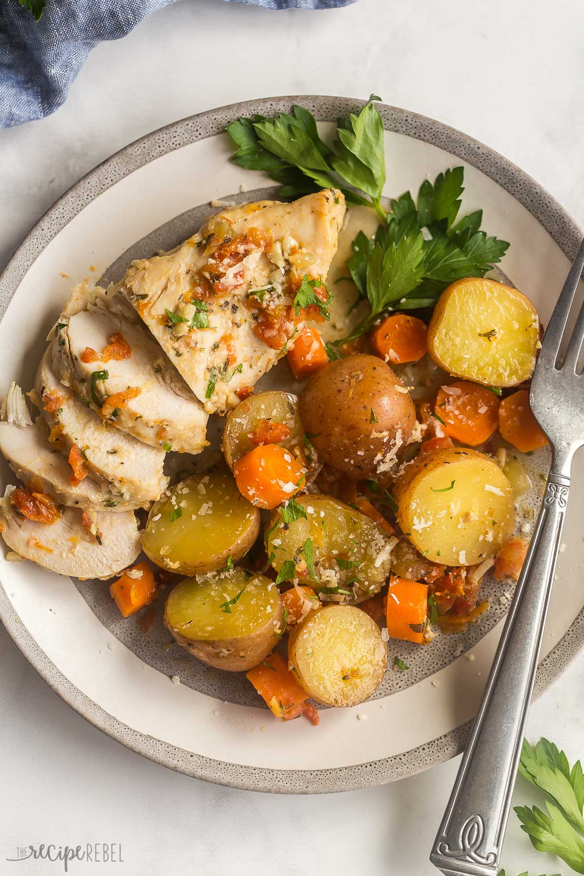 sun dried tomato crockpot chicken on plate with potatoes and carrots