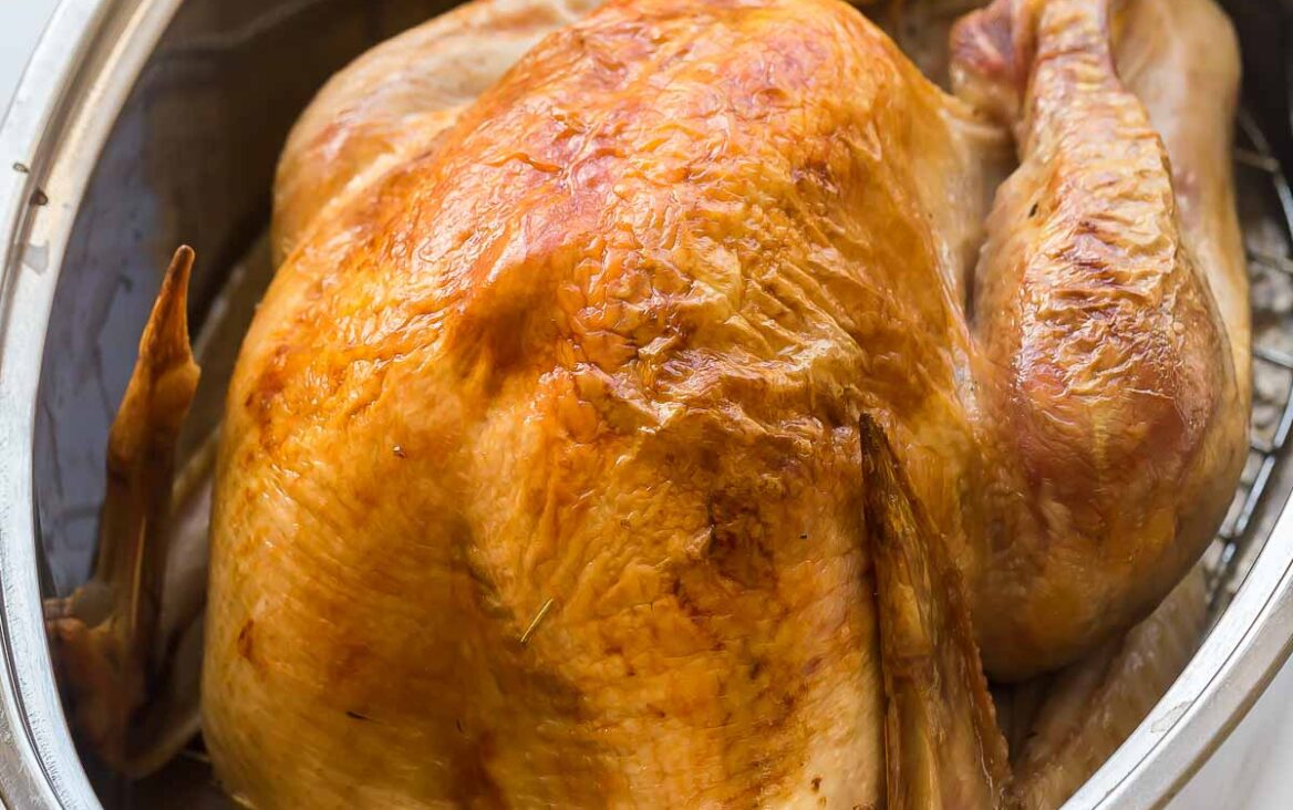 whole roast turkey in roasting pan with golden skin