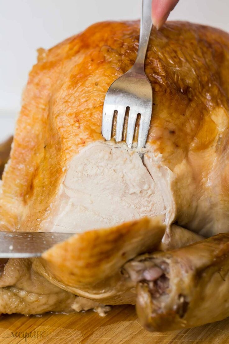 fork and knife being used to slice brined roast turkey