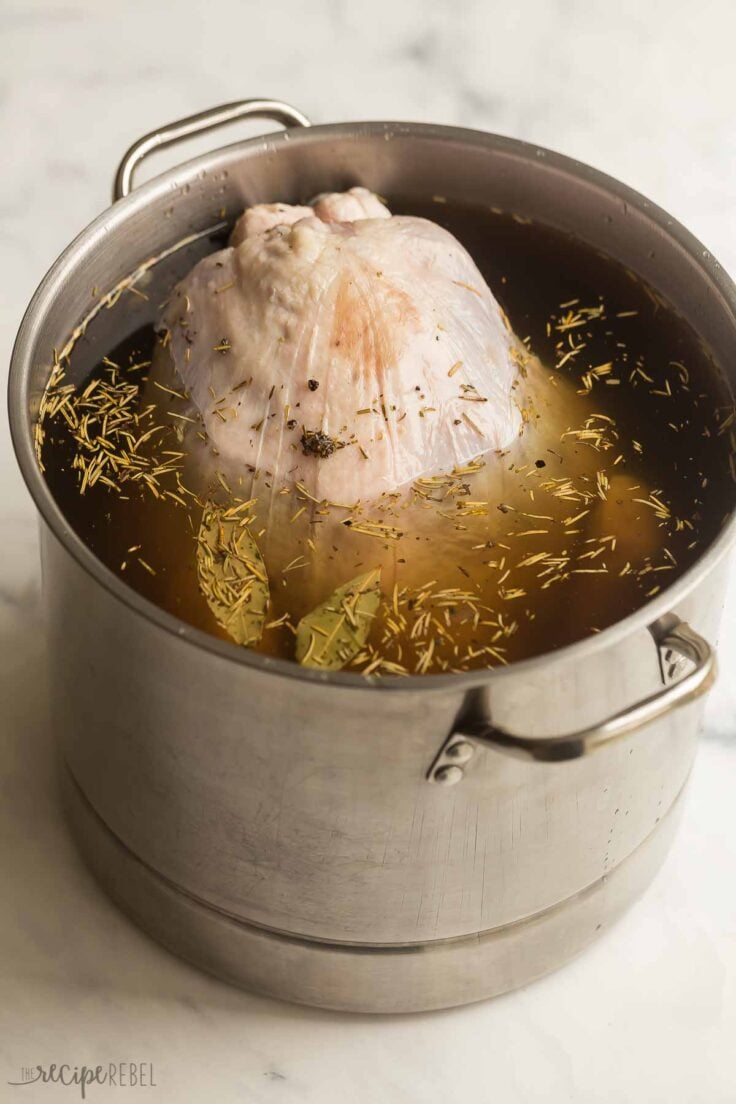 raw turkey being submerged in turkey brine