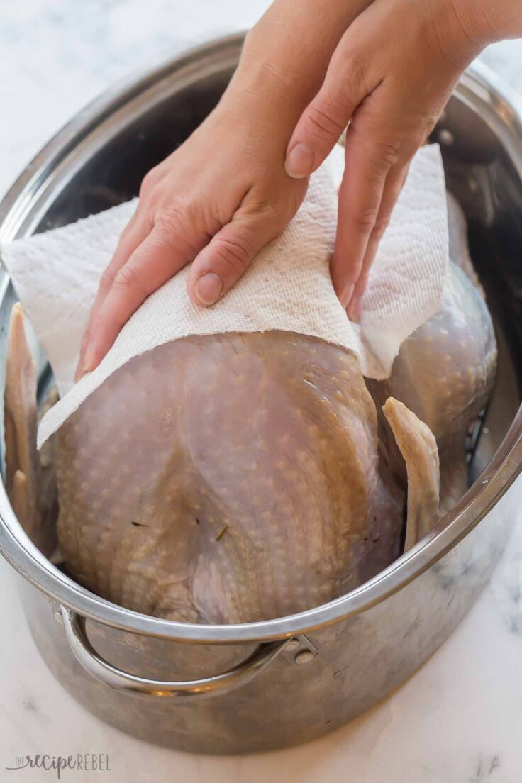 paper towels being used to pay turkey dry after brine