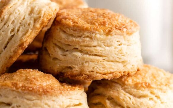 close up image of flaky biscuits with milk in the background
