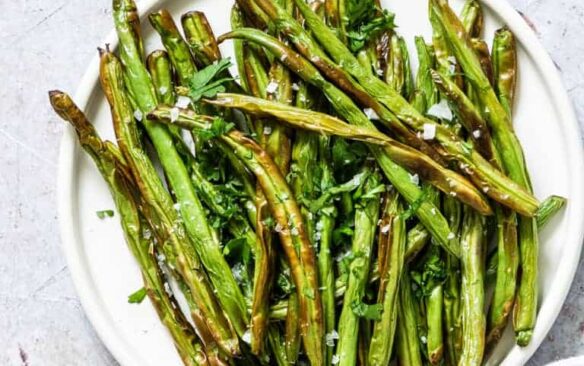 overhead image of air fryer green beans on white plate