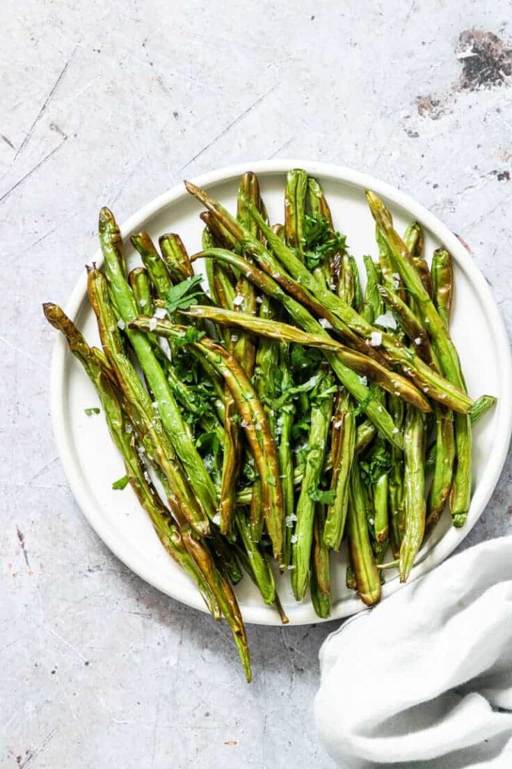 overhead image of air fryer green beans on white plate