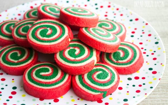 red green and white pinwheel christmas cookies on a red and green spotted plate