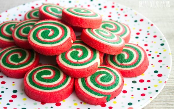 red green and white pinwheel christmas cookies on a red and green spotted plate