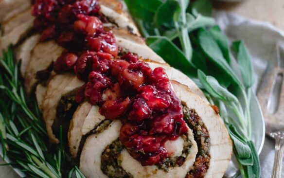 turkey roulade with cherry stuffing on platter with fresh rosemary