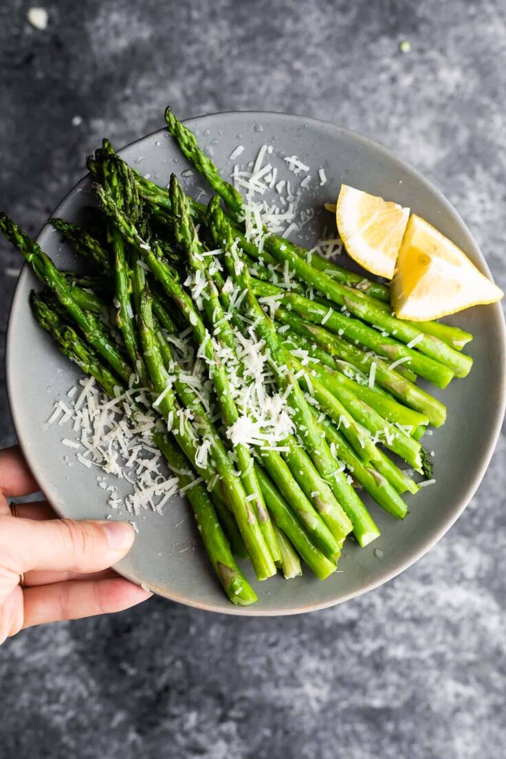 overhead image of air fryer asparagus on plate with parmesan and lemon