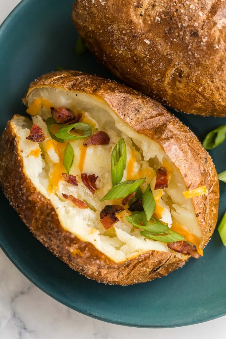 close up image of baked potato with butter cheese and bacon