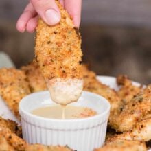 air fryer chicken tenders being dipped into sauce