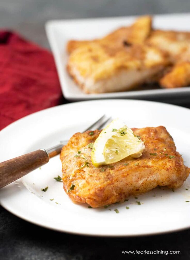 air fryer cod on plate with slice of lemon