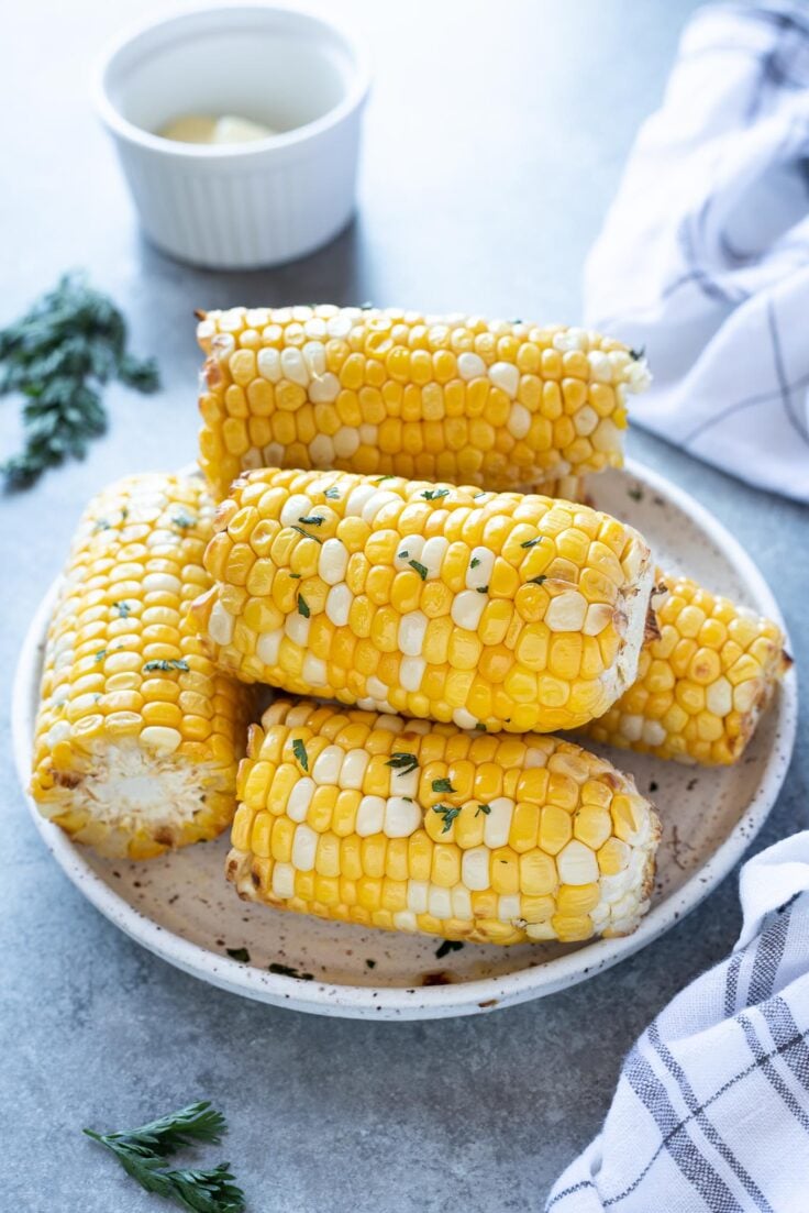 corn cobs cut in half stacked on plate