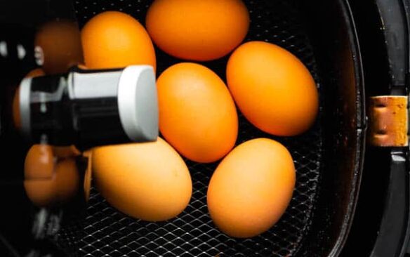 overhead image of whole eggs in air fryer basket