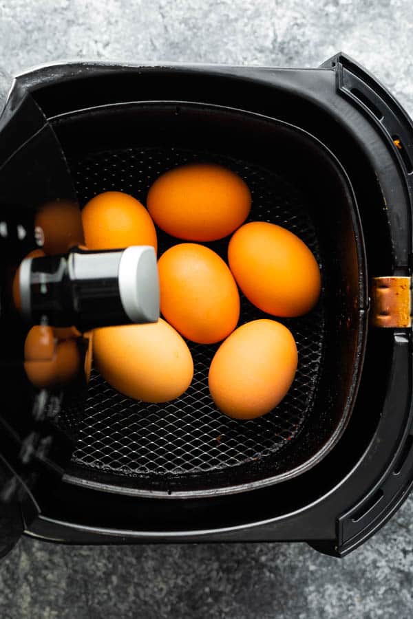overhead image of whole eggs in air fryer basket