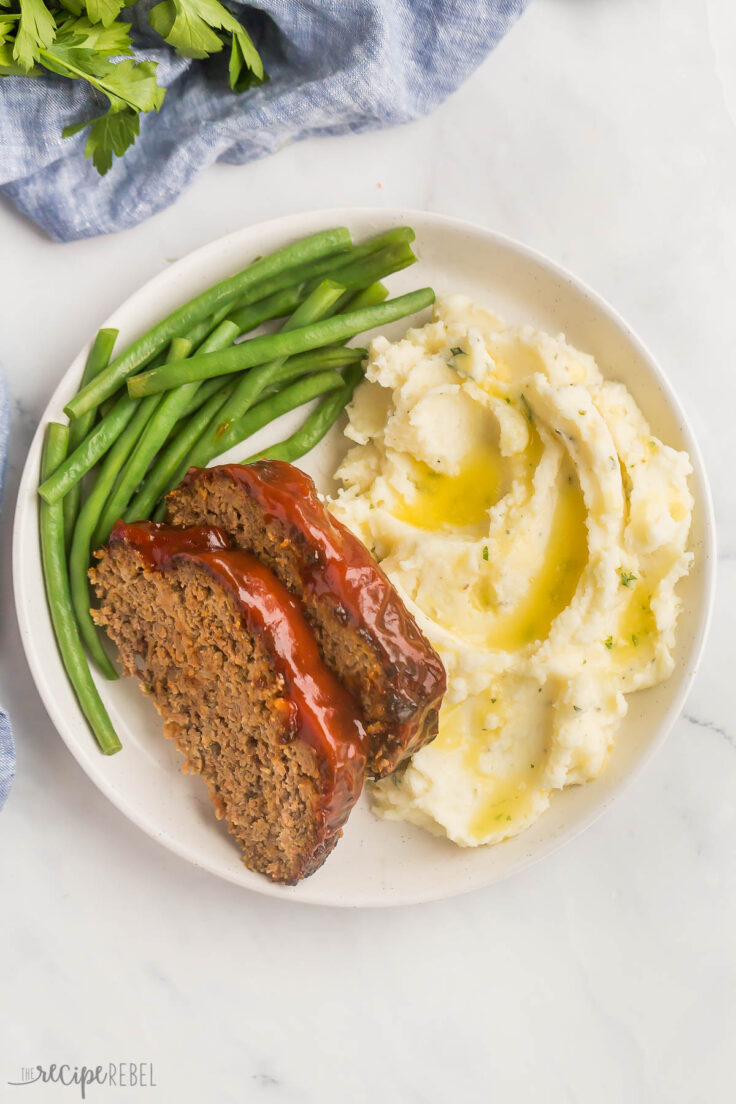 overhead image of two slices of air fryer meatloaf on mashed potatoes