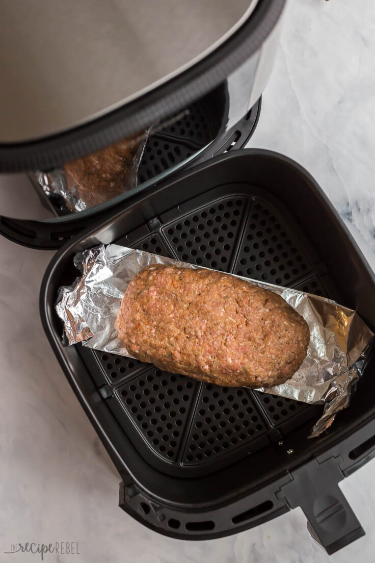 uncooked meatloaf in air fryer on piece of tin foil