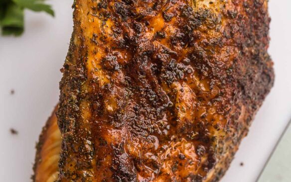 close up pf whole air fryer turkey breast on white cutting board