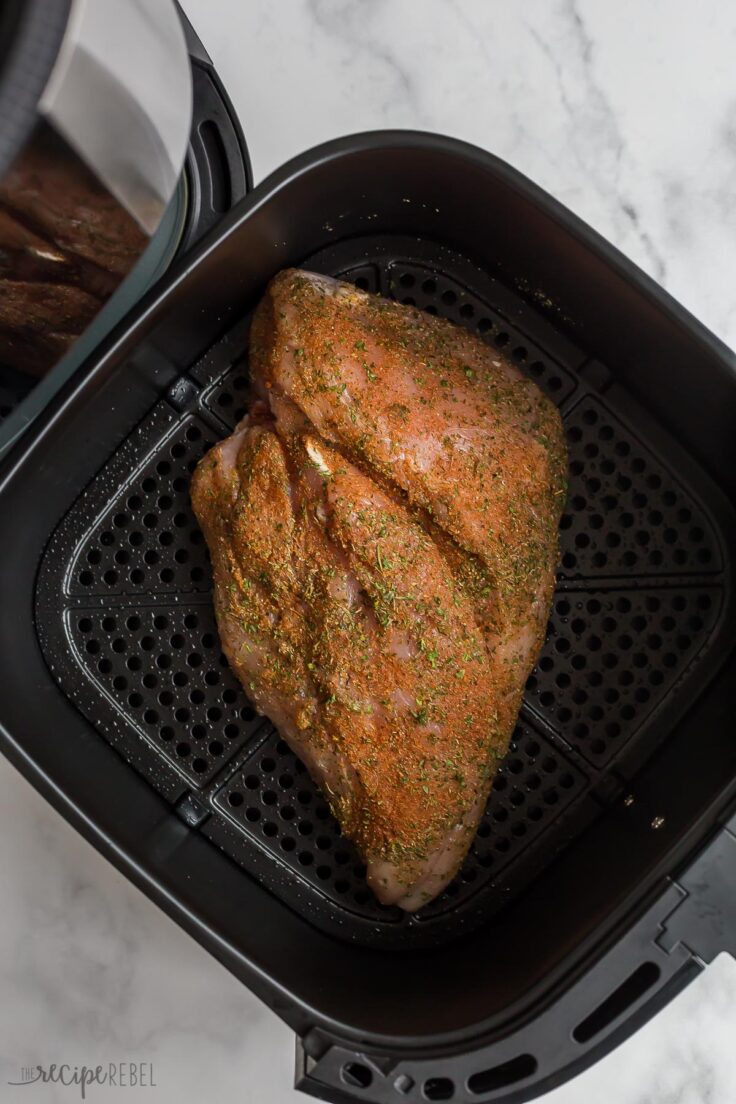 uncooked turkey breast fulled seasoned in air fryer basket
