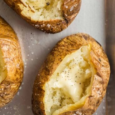 close up overhead image of baked potato split open with butter