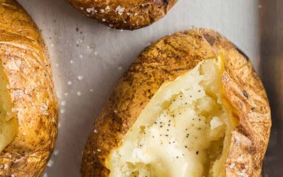 close up overhead image of baked potato split open with butter